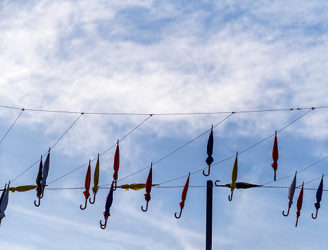 Umbrellas hanging on the wire in the air, cloudy sky on the background in Turkey.