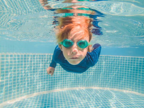 istock Boy having fun playing underwater in swimming pool on summer vacation 1304195701