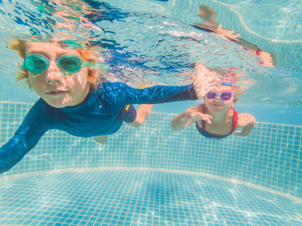 istock Kids having fun playing underwater in swimming pool on summer vacation 1304195706