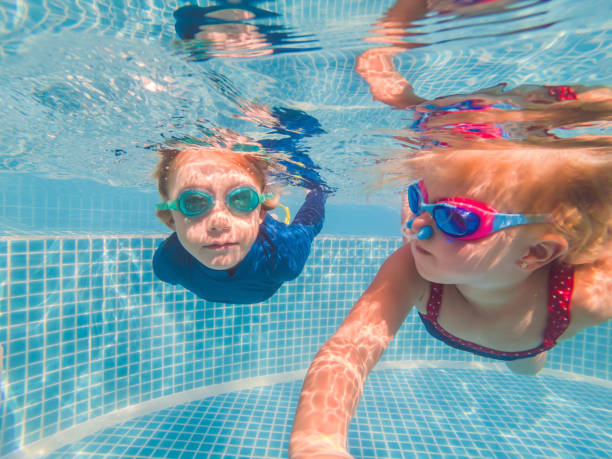 istock Kids having fun playing underwater in swimming pool on summer vacation 1304195710