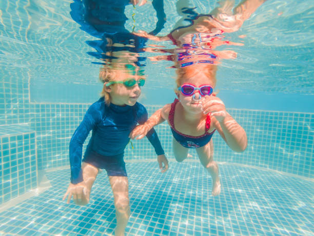 istock Kids having fun playing underwater in swimming pool on summer vacation 1304195713