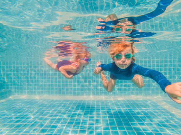 istock Kids having fun playing underwater in swimming pool on summer vacation 1304195718