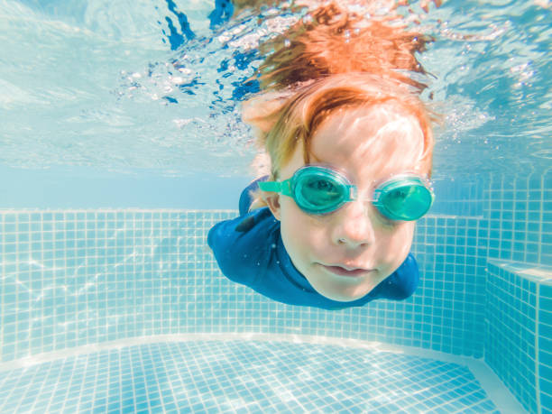 istock Boy having fun playing underwater in swimming pool on summer vacation 1304195728
