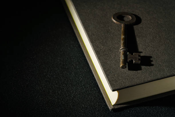 istock Vintage key and hardback book on dark background 1304196253
