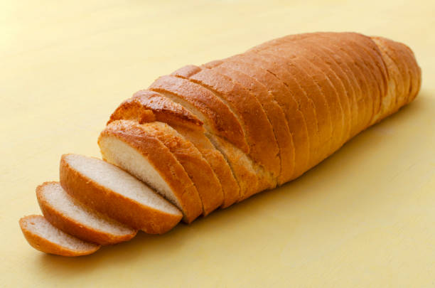 istock Closeup of sliced whie bread on the bright yellow surface 1304196285