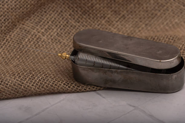 istock Antique glass syringe with reusable needle. background on brick wall. 1304196530