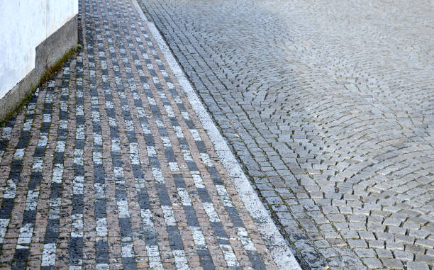 istock concrete white park bench block shape on square, clean smooth surface. paving of cubes, circular spaces for trees stripes of paving is in strips of small cubes folded into a mosaic of marble, granite 1304196653