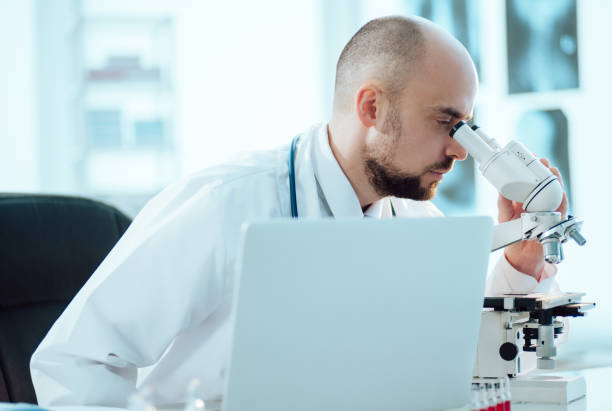 istock scientist works on a laptop while sitting at a table in a medical laboratory 1304196971