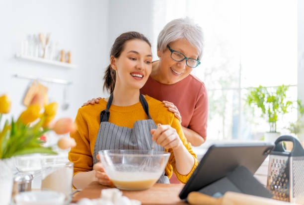 famiglia stanno preparando panetteria insieme - grandmother senior adult family domestic kitchen foto e immagini stock