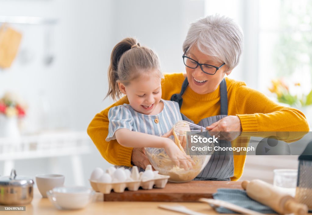 family are preparing bakery together Happy loving family are preparing bakery together. Granny and child are cooking cookies and having fun in the kitchen. Grandmother Stock Photo