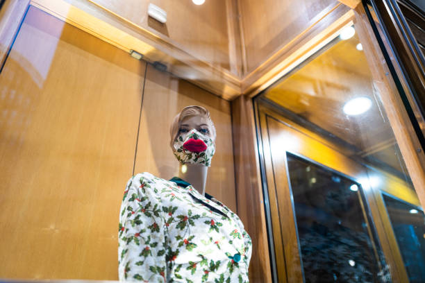 istock Mannequin wearing protective face mask in shop window 1304198908