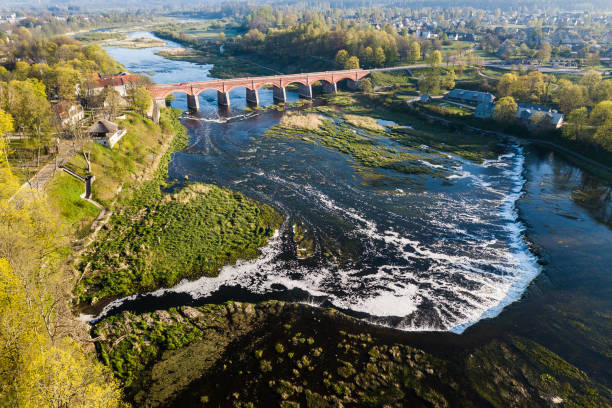 istock Venta Rapid waterfall, the widest waterfall in Europe and long brick bridge. 1304198972