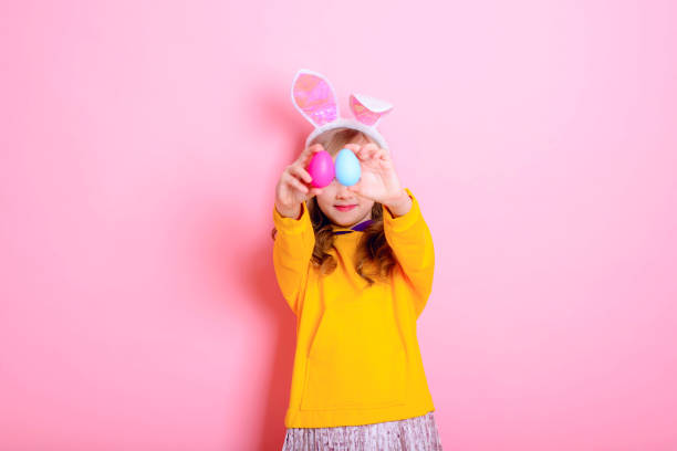 istock Happy Easter! Cute girl kid blonde with Bunny ears holds bright Easter eggs. Traditions, holidays, spring, religion concept. 1304202644