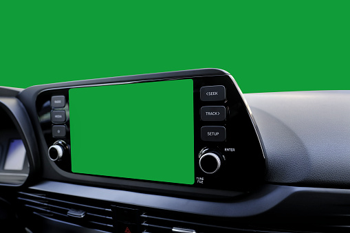 Green navigation screen on dashboard and green windscreen from inside of a modern new car.