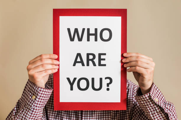 istock Man holding paper with text who are you 1304205582