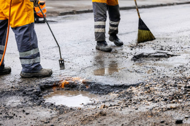 istock pothole repair - maintenance service workers working on the road 1304206413