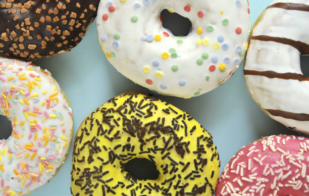 istock Delicious donuts on light pastel color background. 1304207923