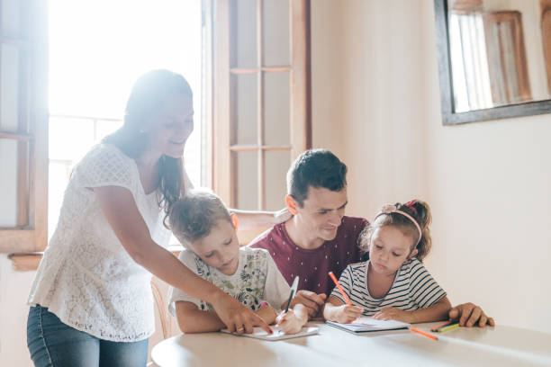 istock Two children family drawing behind table 1304209413