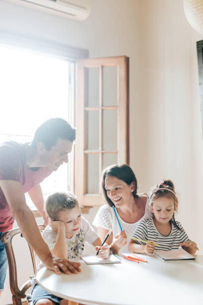 istock Two children family drawing behind table 1304209422