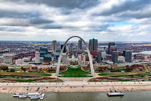The skyline of St. Louis, Missouri beyond the famed Gateway Arch along the banks of the Mississippi River shot from an altitude of 600 feet over the river.