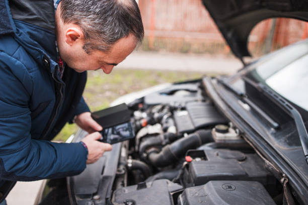 istock Man using phone to take a photo of car engine 1304212163