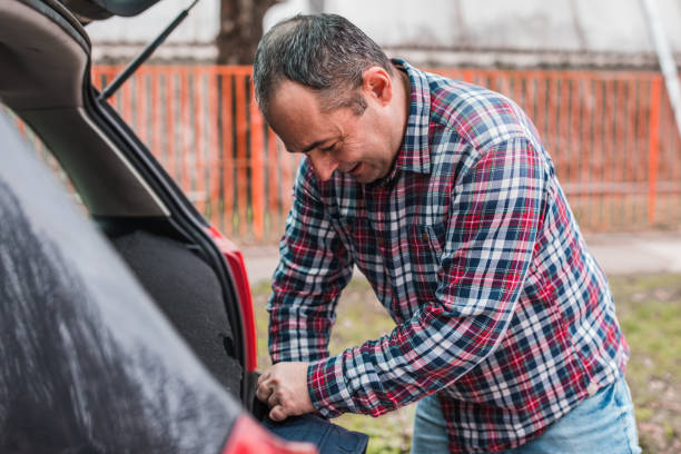 istock Cheerful man taking things out of car trunk 1304212293