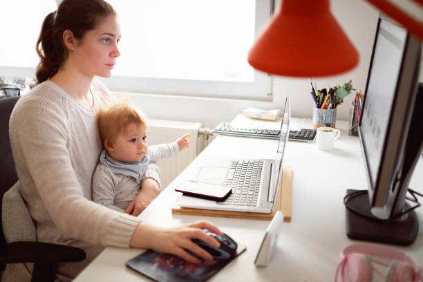 istock Multi-tasking mother working on the computer while while her baby boy sitting in her lap 1304213680