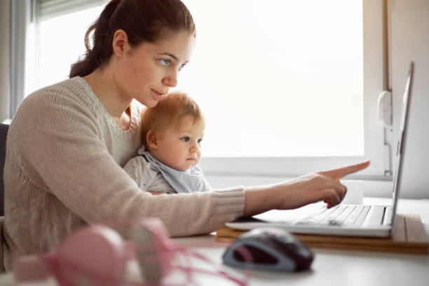 istock Mother with baby working in home office 1304213694