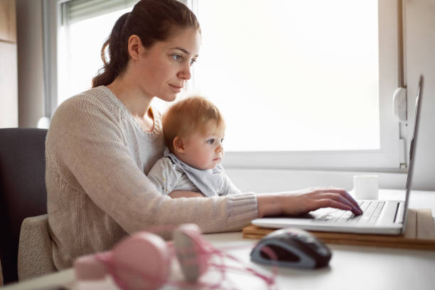 istock Mother with baby son working in home office 1304213700
