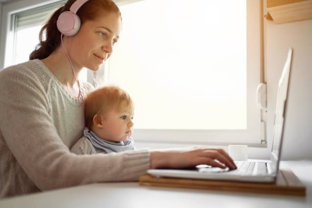 istock Multi-tasking mother holding her baby boy and working at home offce 1304213713