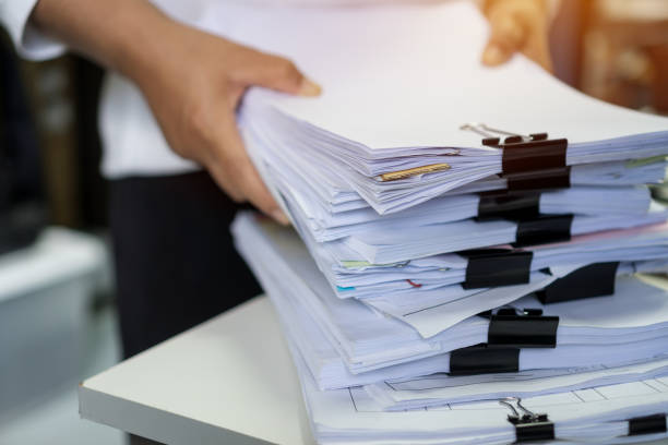 istock Stacks of lot documents report papers with clips waiting be managed by office workers arranging on desk in busy office. Concept of workload in business finacial paperwork information or investigate 1304215353