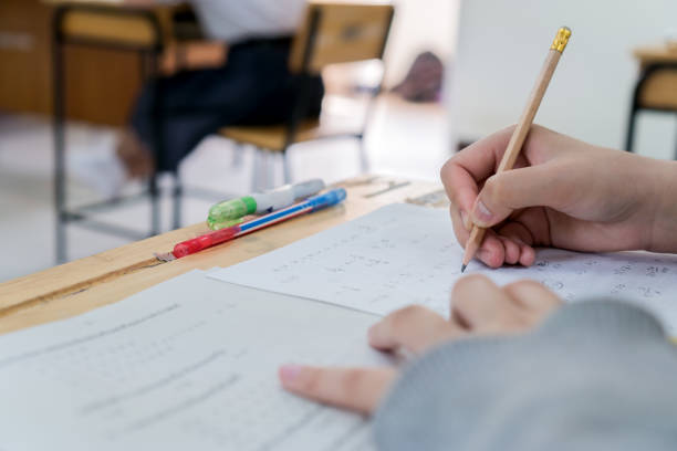 istock student taking notes lecture in high school or university with holding pencil writing on paperwork sheet and taking final exam in examination classroom 1304215428