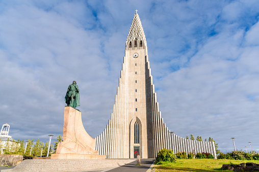 Reykjavik, Iceland - July 09, 2020: View of Hallgrimskirkja parish church with statue of Leif Eriksson in foregrond in the city centre on a sunny summer evening. The church is named after the Icelandic poet and clergyman Hallgrímur Pétursson, author of the Passion Hymns.