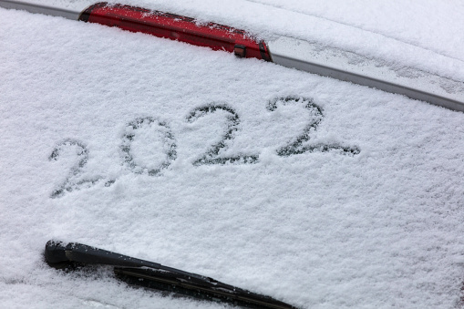The new year 2022 written on a car windshield