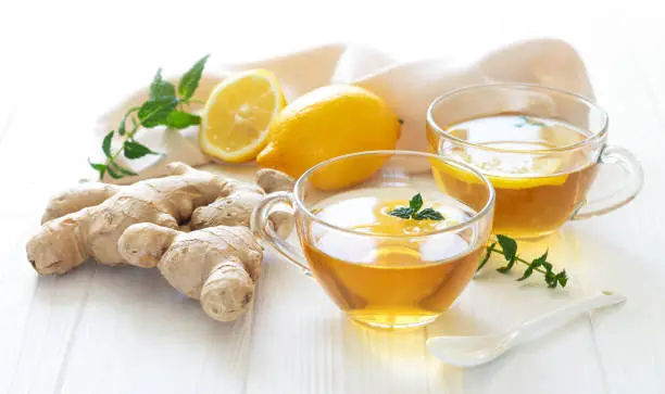 Herbal ginger tea for boost your immune. Two glass mugs of healthy hot drink close-up