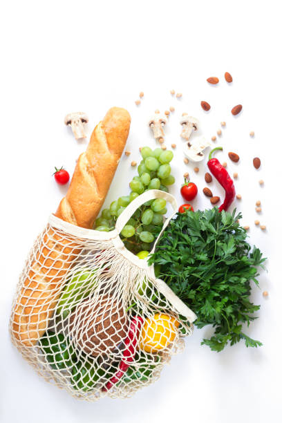 Full mesh bag of different health food on white background Full mesh bag of different health food on white background. Top view flatlay feeding grapes stock pictures, royalty-free photos & images