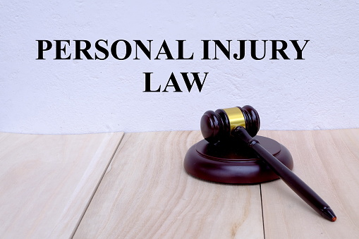 Personal Injury Law written on the wall with gavel on wooden background. Law concept.