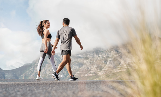 Shot of a sporty young man and woman exercising together outdoors