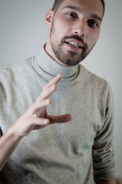 istock Portrait of a young man with a short beard speaks gesturing with his hands to explain something 1304228274