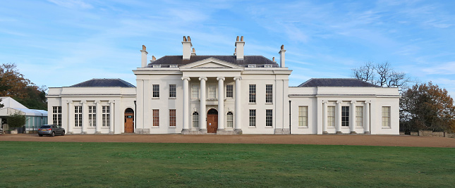 Public Hylands park with house, mansion or stately home and grounds with drive and lawn. Bridgerton style neo classical regency Georgian Palladian villa. Front elevation and main entrance. Outdoors on a bright winters day. Chelmsford, Essex, United Kingdom, November 22, 2021