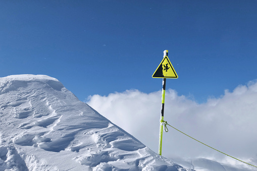 Fall warning sign from the mountain in winter. Alpine landscape.