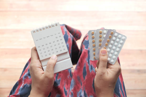 istock women hand holding birth control pills and calendar 1304229204