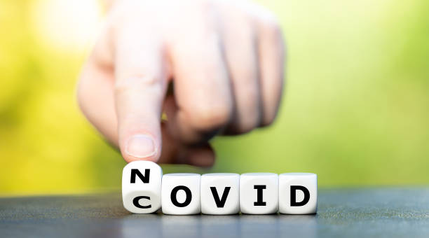 istock Symbol for wipe out covid 19. Hand turns dice and changes the expression 