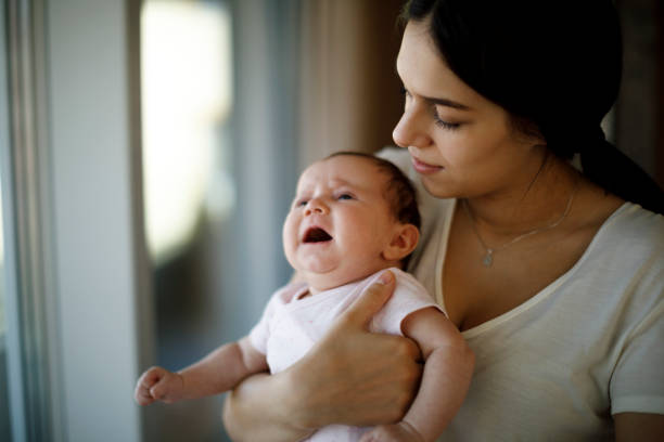 istock Newborn baby crying in mother hands 1304231289