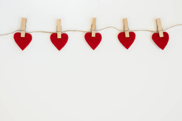 istock Valentine's day card. White background with red hearts on clothespins. 1304232519