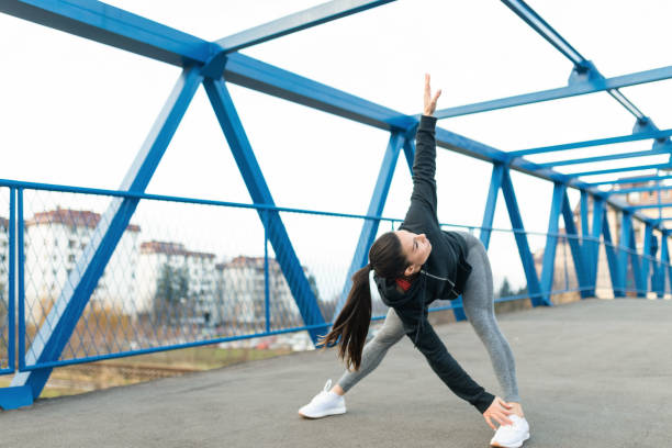 istock Young woman warming up before running 1304232863