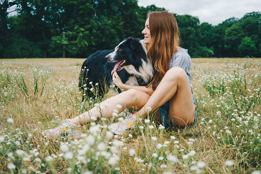 Young woman playing with a Border Collie dog in the park