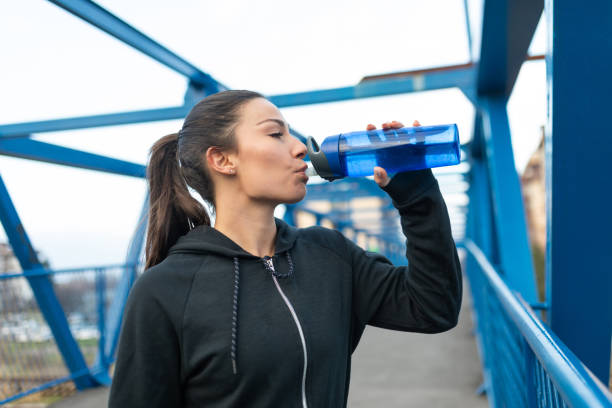 istock Felame athlete drinking water after exercise outdoors 1304233157