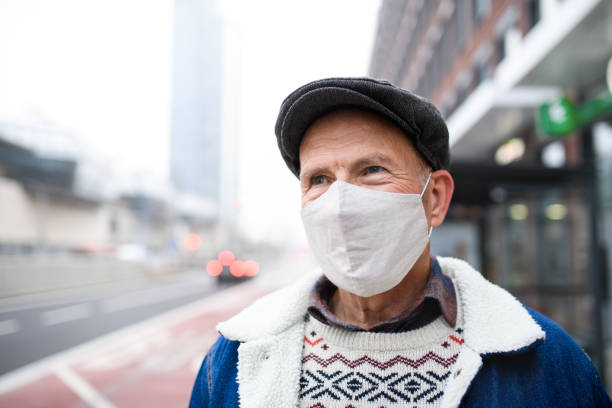 felice uomo anziano in piedi all'aperto per strada in città. concetto di coronavirus. - ascot foto e immagini stock