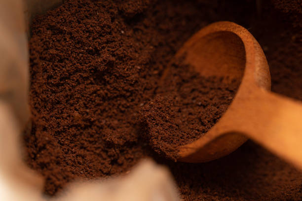 Wooden spoon taking ground coffee from a bag.